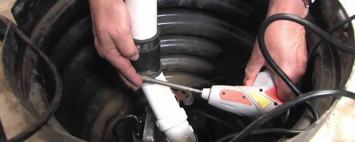 Sump pump installation technician connecting PVC discharge piping in Buffalo, NY